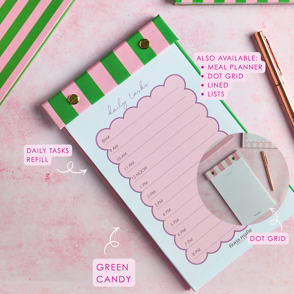 A styled flat-lay of a pink and green striped daily tasks refill notepad on a pink textured background, with a rose gold pen, a dot grid notepad, and text callouts.