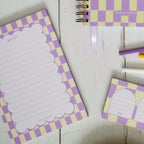 Checkered notebooks with stationery items on a wooden surface
