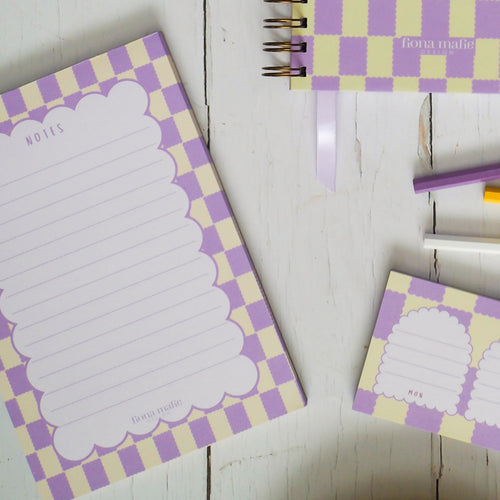 Checkered notebooks with stationery items on a wooden surface