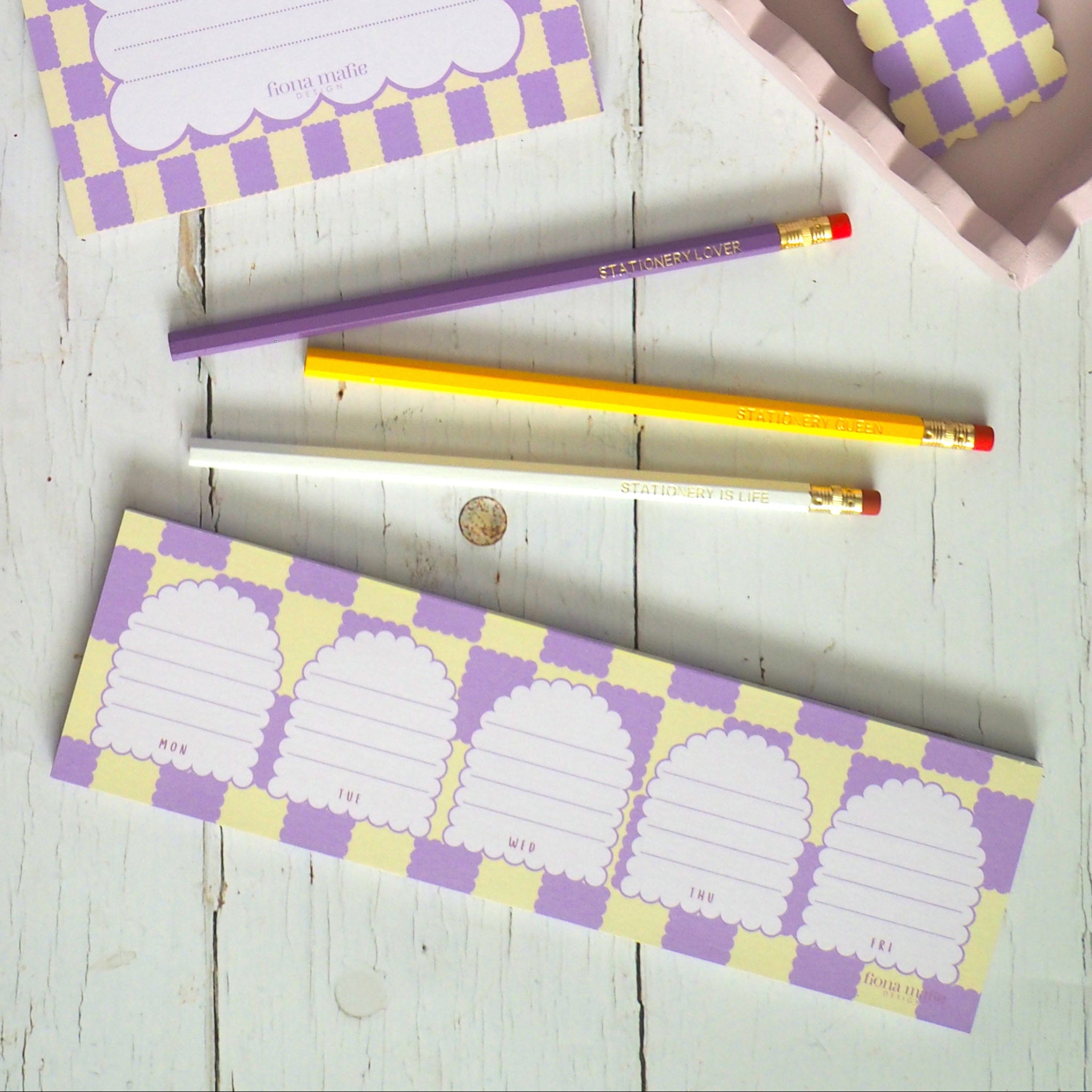 Checkered notebooks and stationery items on a wooden surface