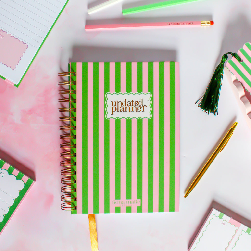 Pink and green striped planner with 'undated planner' text on a colorful background