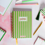 Pink and green striped planner with 'undated planner' text on a colorful background