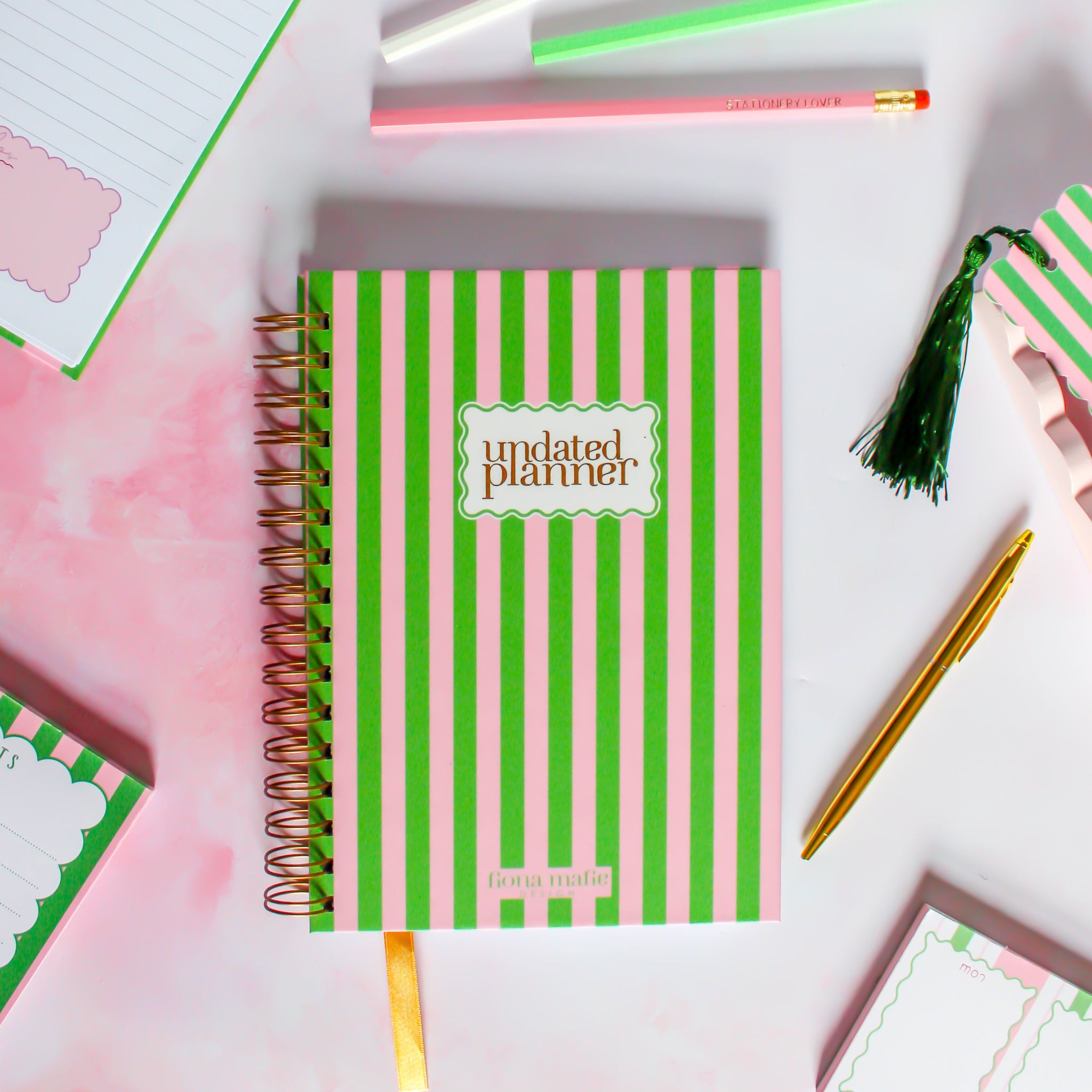 Pink and green striped planner with 'undated planner' text on a colorful background