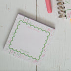 Stationery items including notebooks, pens, and a teacup on a wooden surface.