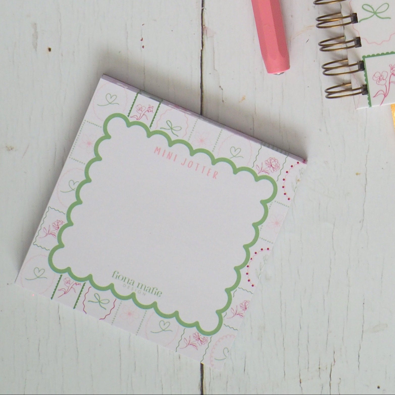 Stationery items including notebooks, pens, and a teacup on a wooden surface.