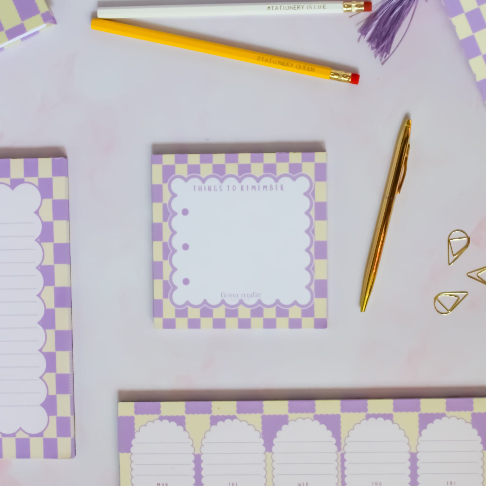 Checkered notepads with purple and yellow design on a light gray background