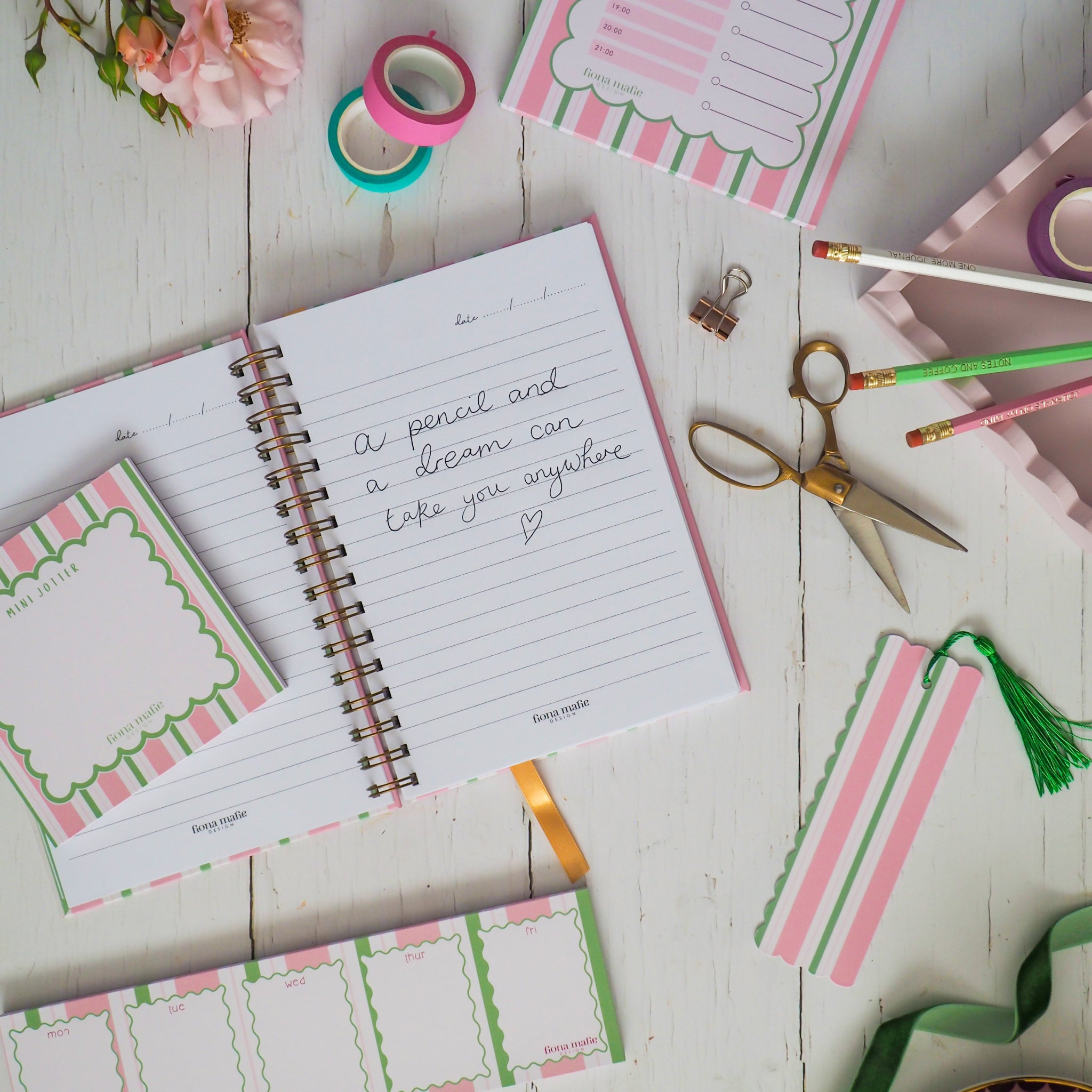 Notebook with printed pages and stationery items on a wooden surface