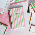 Striped planner with 'undated planner' text on a white surface with stationery items.