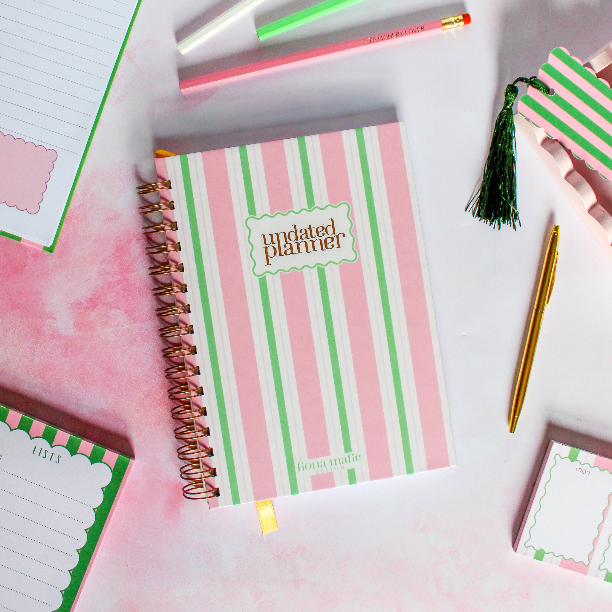 Striped planner with 'undated planner' text on a white surface with stationery items.