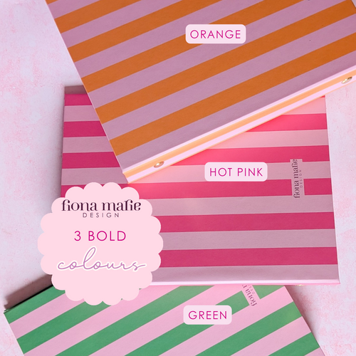 Three striped notebook covers stacked diagonally on a pale pink background. The top notebook has orange and dusty pink stripes and is labeled 'ORANGE'.